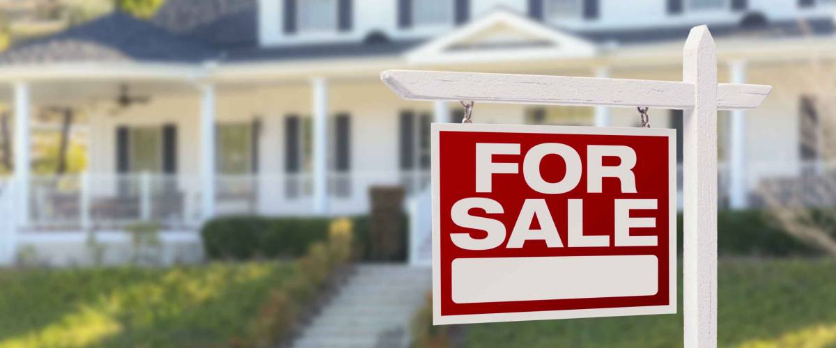 Home For Sale Real Estate Sign in Front of Beautiful New House.