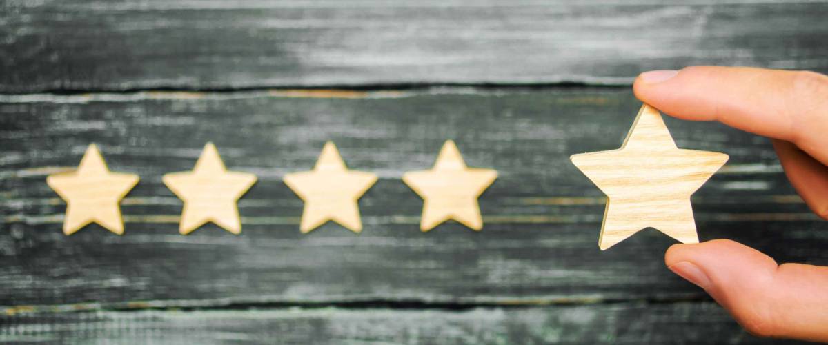 The businessman's hand holds the fifth star. A new star, achievement.The concept of the rating of hotels and restaurants, the evaluation of critics and visitors. Quality level, good service.