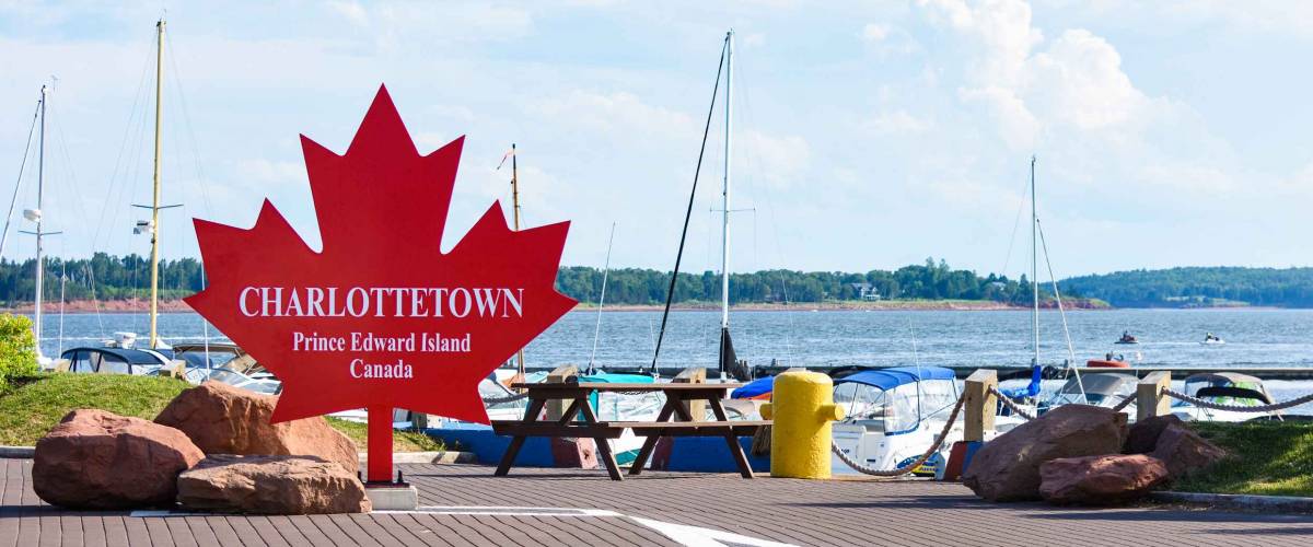 Charlottetown sign on the red maple leaf at the port harbor in Prince Edward Island, Canada.