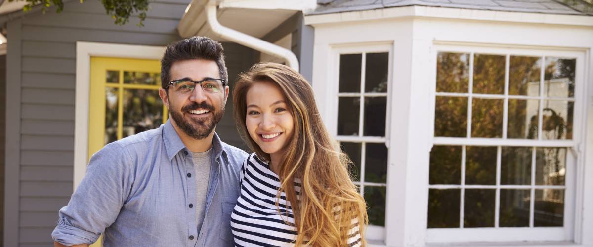 Couple in front of new house