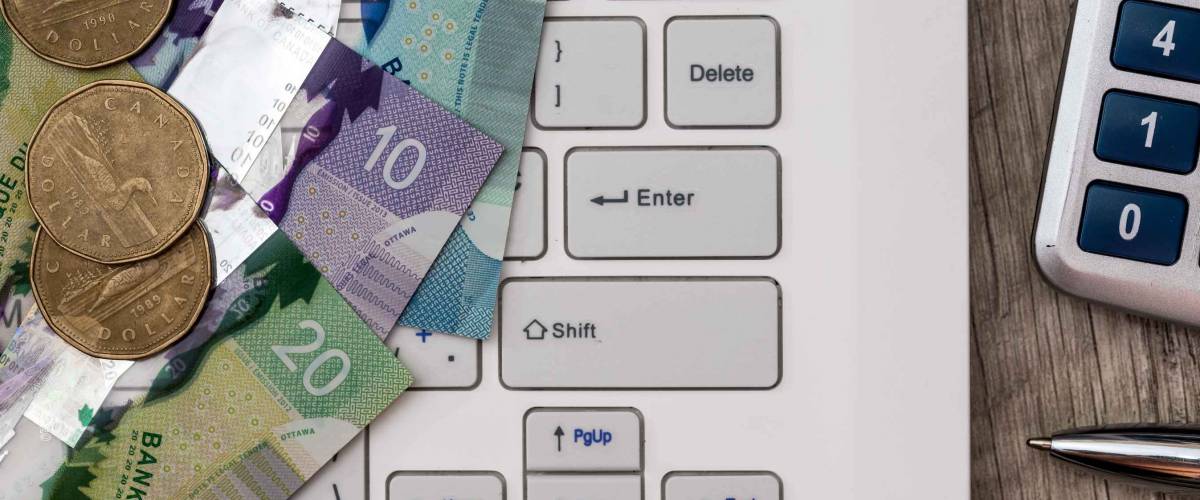 Canadian dollar with laptop - business concept
