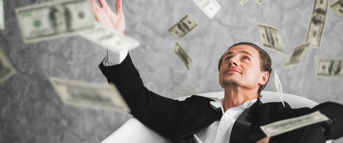 Business man throwing his windfall money into the air