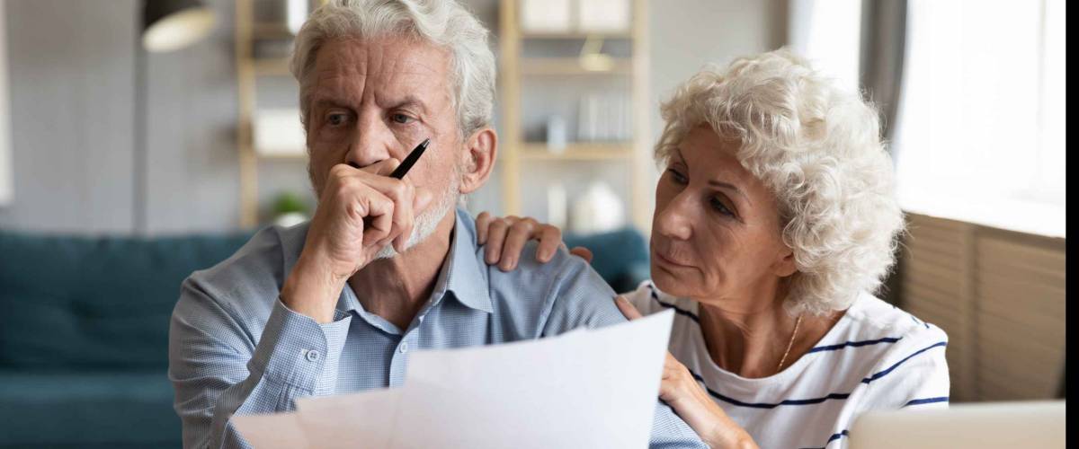 Compassionate elderly woman supporting upset stressed mature husband.