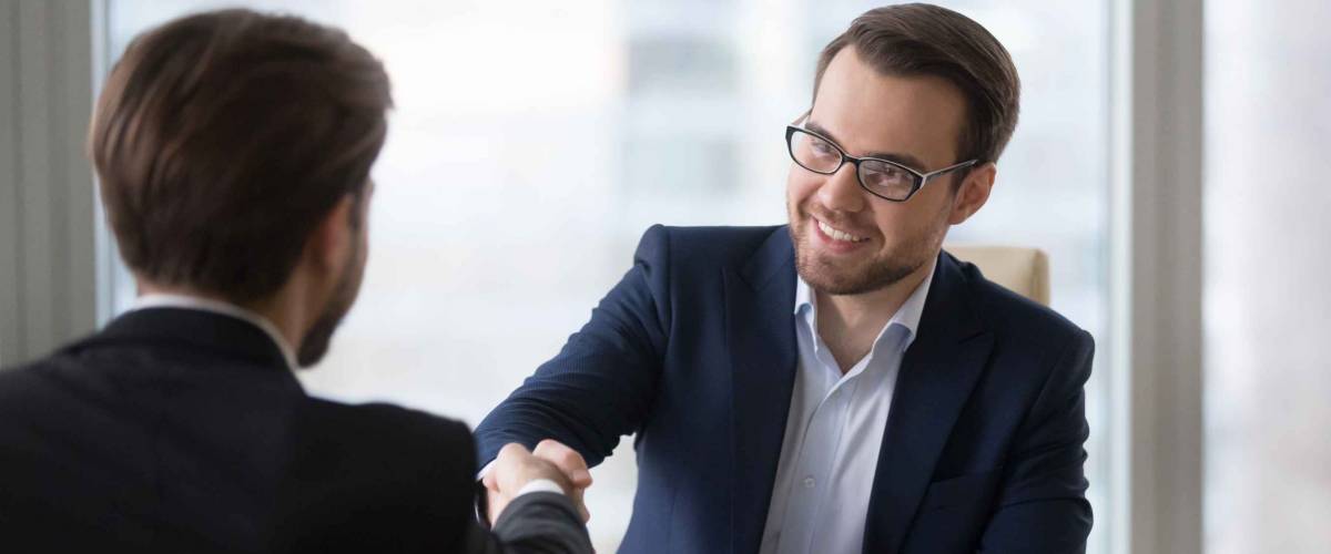 Smiling hr manager advisor insurer bank executive handshaking client.