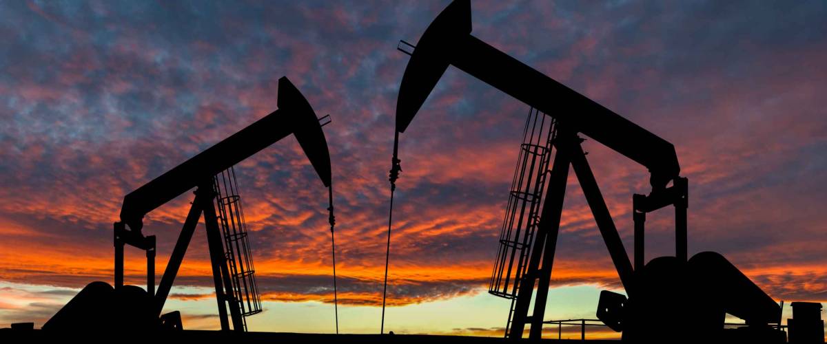 Dramatic sky over two pumpjacks in rural Alberta, Canada. These jacks can extract between 5 to 40 liters of crude oil and water emulsion at each stroke.