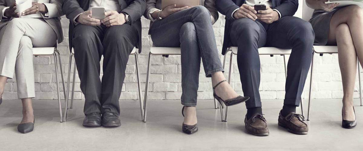 Line up of people sitting in chairs from the waist down