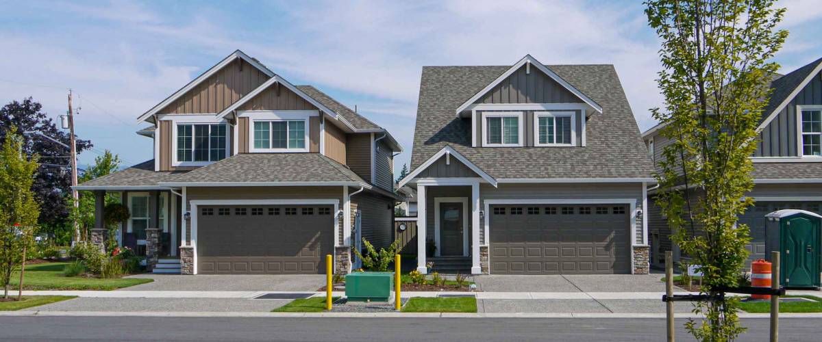 Brand new residential houses with concrete driveway and asphalt road in front