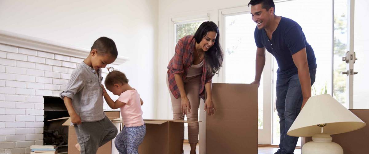 Family Unpacking Boxes In New Home On Moving Day