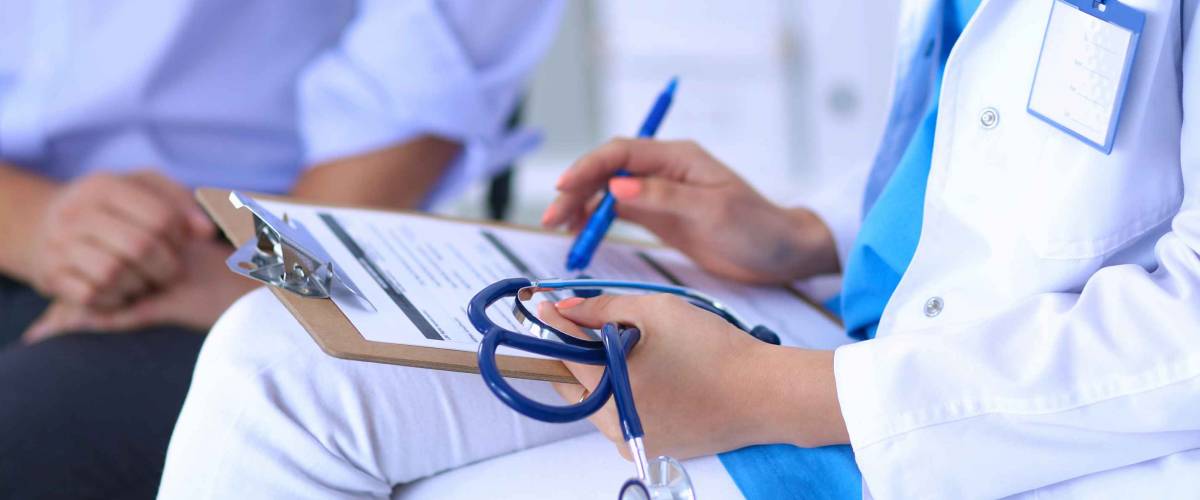Doctor woman sitting with male patient at the desk