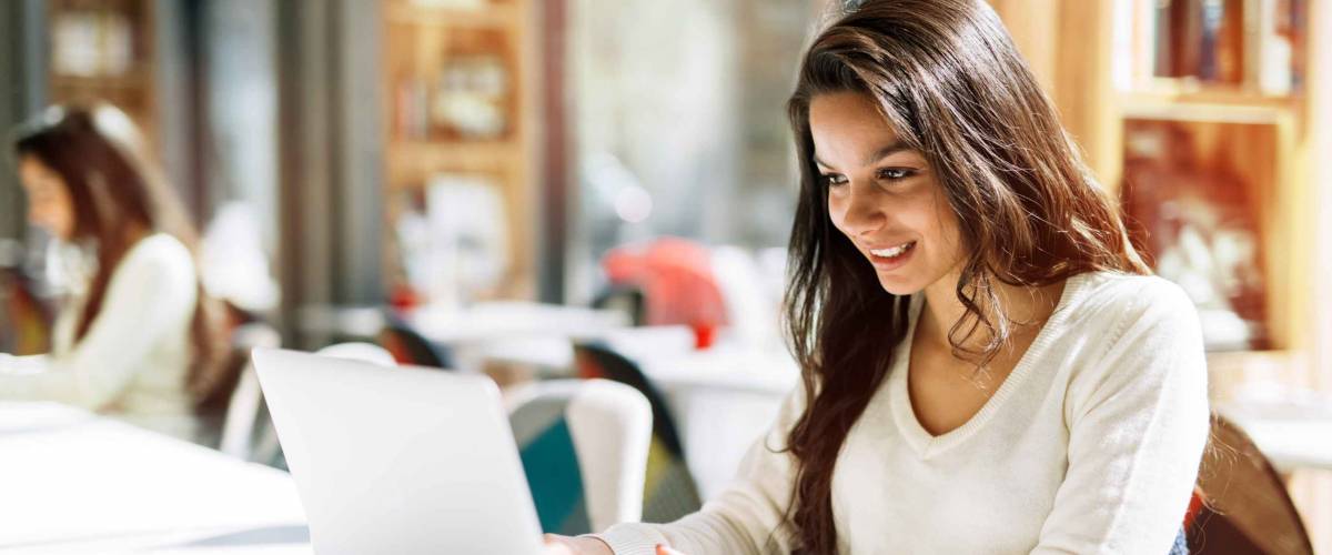 Young woman using laptop in cafe