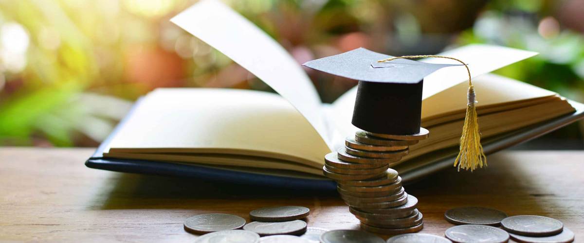 Graduation cap on saving coins for concept finance and education scholarships