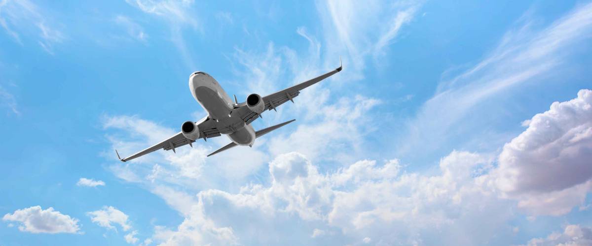 White passenger airplane over the clouds - Travel by air transport