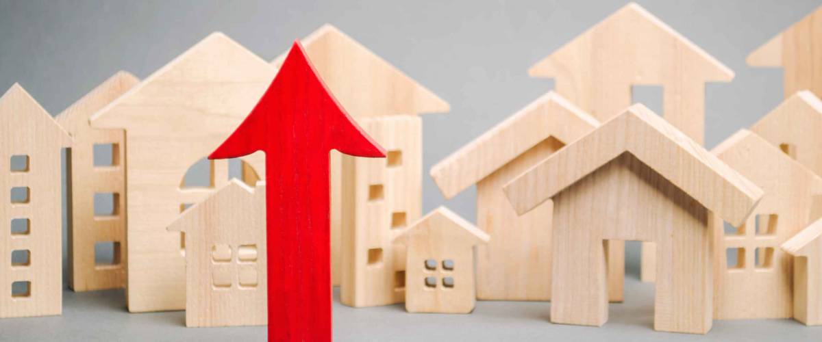 Red arrow up and miniature wooden houses.