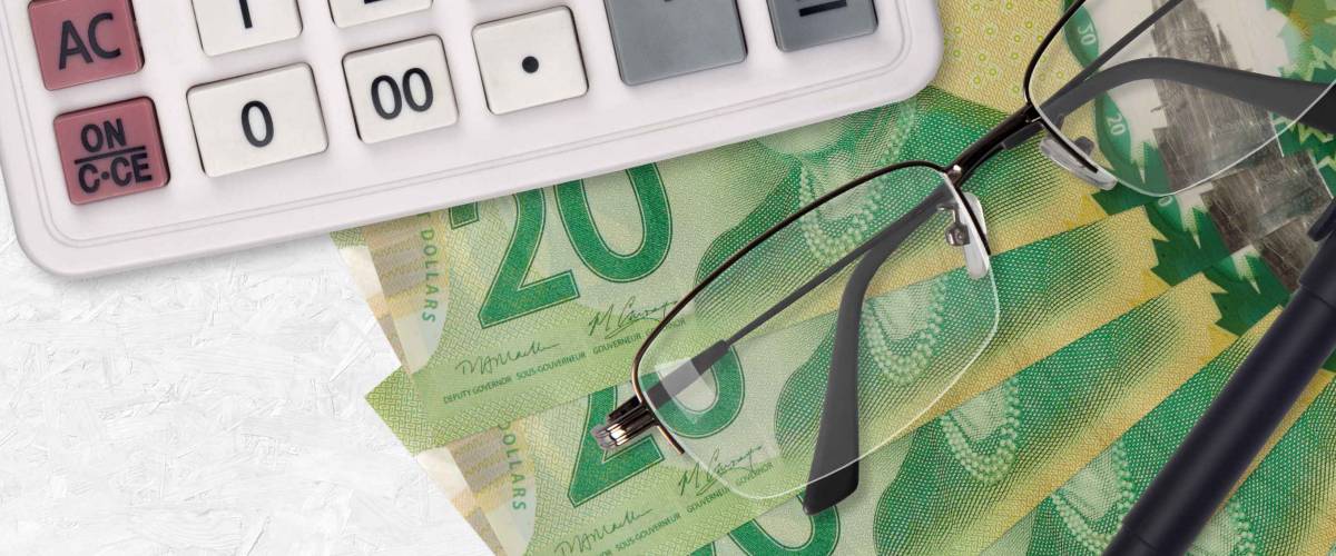 20 Canadian dollars bills fan and calculator with glasses and pen. Business loan or tax payment season concept