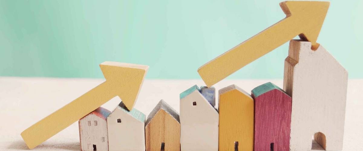 Wooden houses with yellow arrows up. housing boom, property market growing, high demand for real estate, house prices rising concept