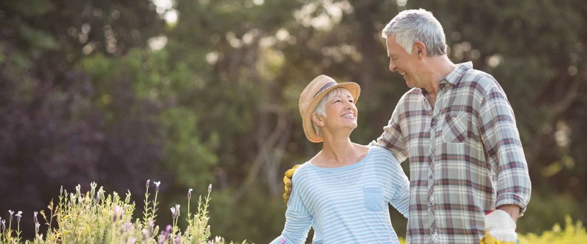 Happy senior couple standing in backyard