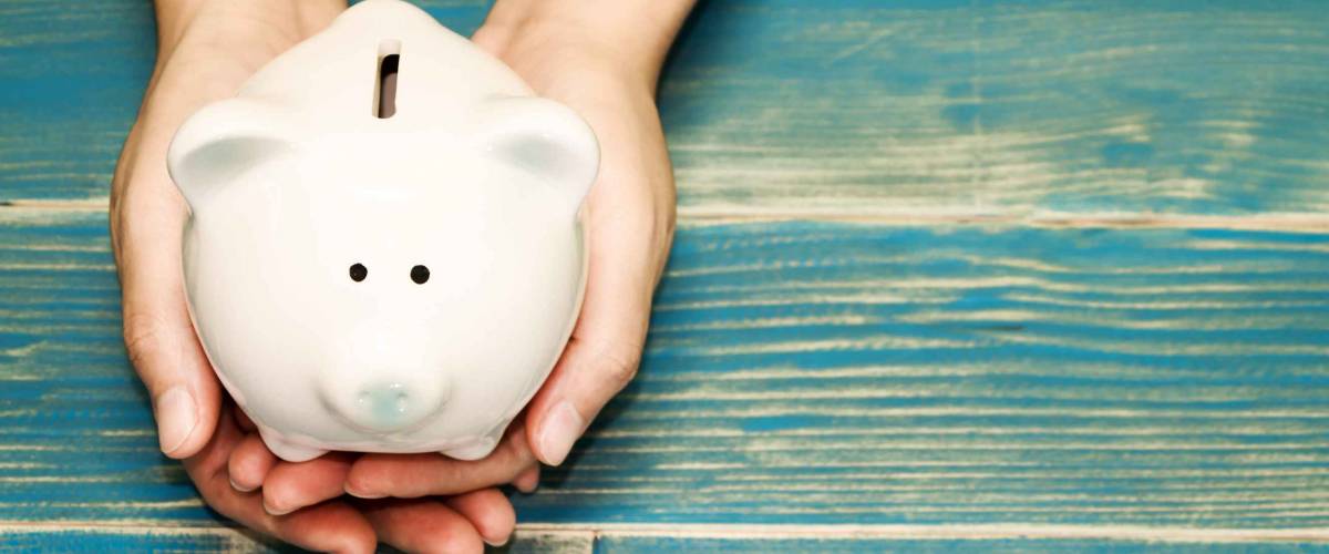Women hold a pig bank on the vintage blue background, a saving money for future investment concept.