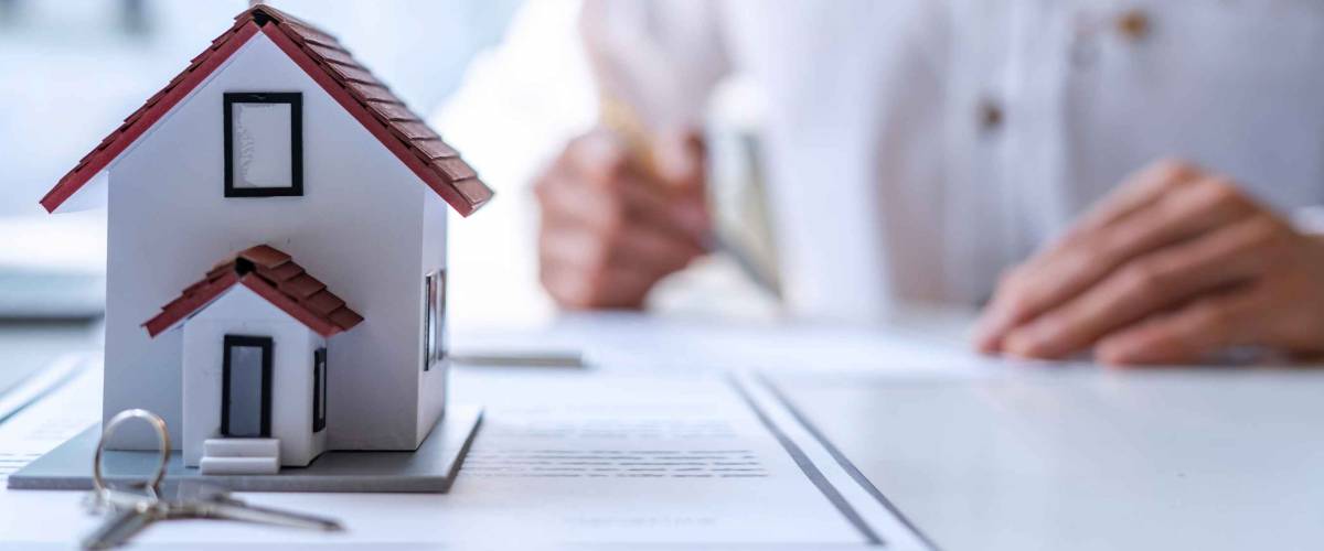 New homebuyers are signing a contract to buy or sell a home at an agent's desk to meet the deal, purchase contract concept. Or selling houses and land