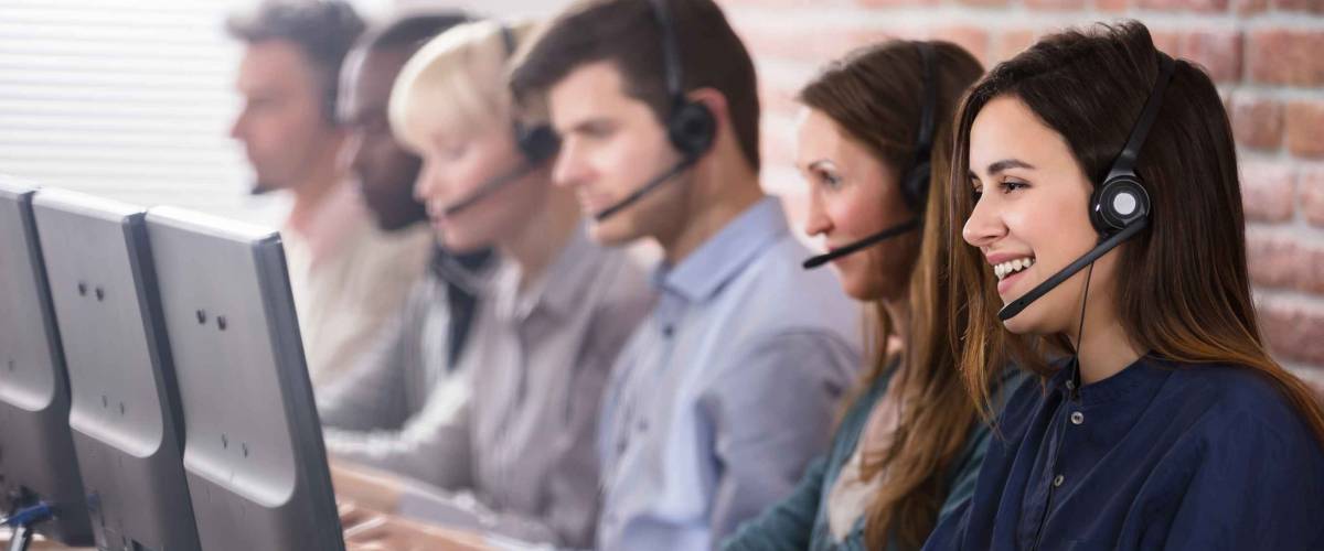 Positive Female Customer Services Agent With Headset Working In A Call Center