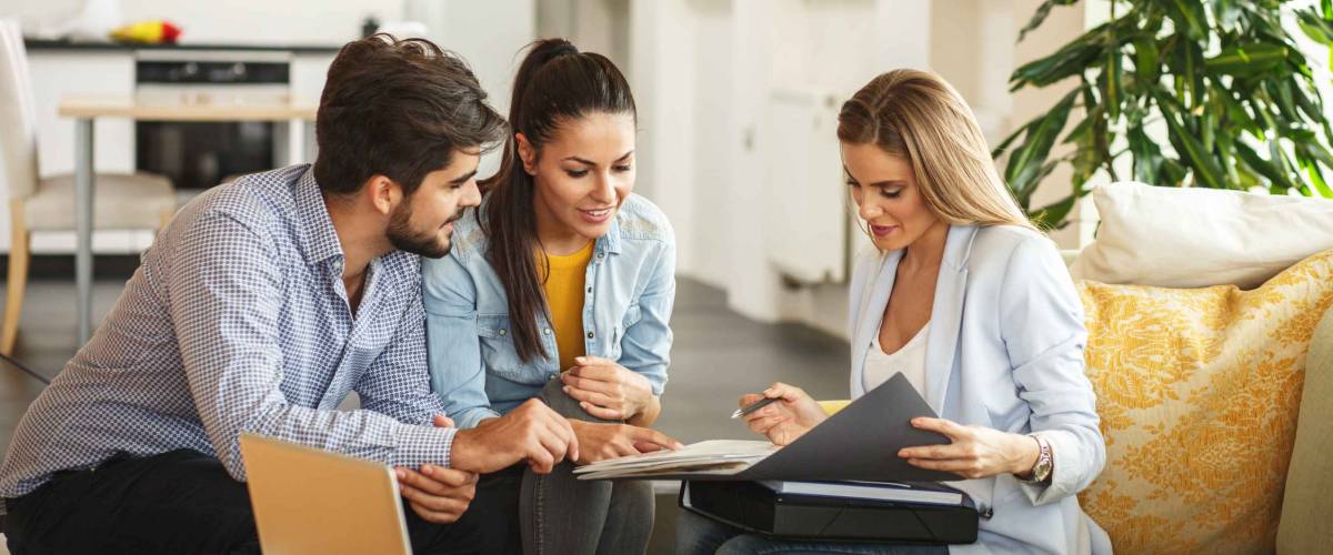 Female Real Estate agent offer home ownership and life insurance to young couple.