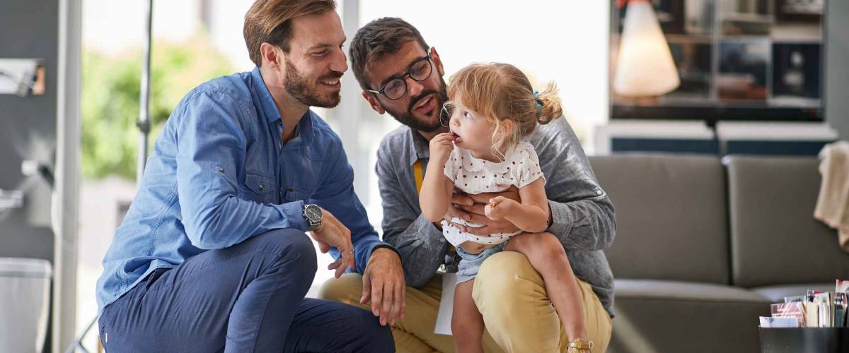 gay parents with child girl in store for household