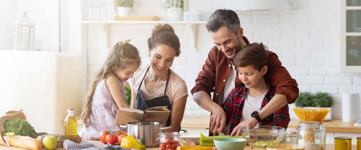 Happy family cooking together in kitchen.