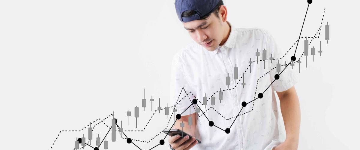 New generation investment in a new era Asian teenagers trade stocks through an app on their mobile phone.