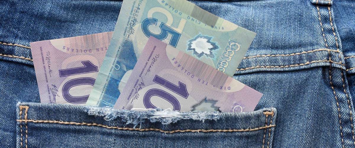 A close up image of Canadian money in a pants pocket.