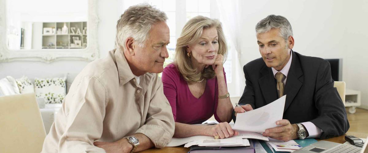 Mature couple sitting at table with financial advisor