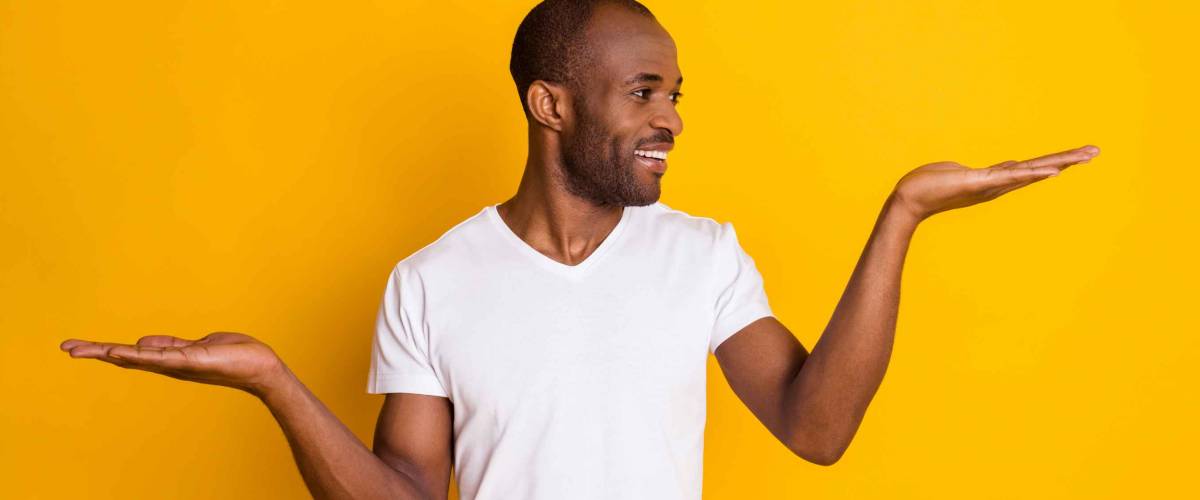 Portrait of positive afro american guy hold hand demonstrate ads promo recommend suggest select wear casual style clothes isolated over bright color background