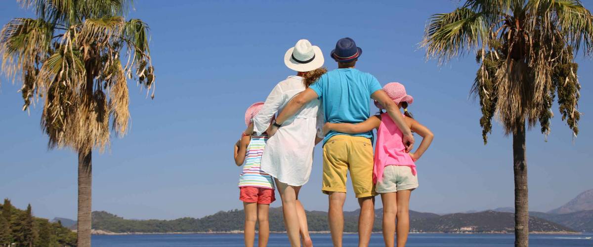 Family with two children standing on the beach on sea coast