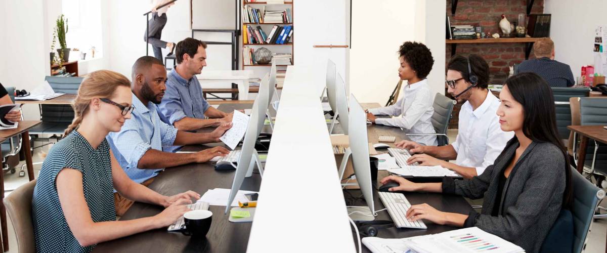 Business colleagues working at a busy open plan office