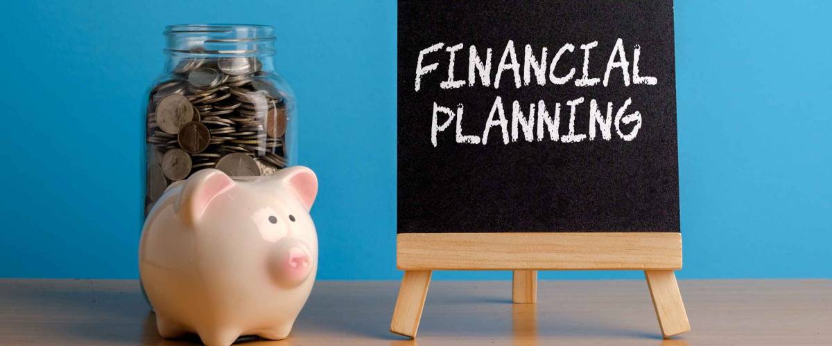 Financial Planning, financial concept. Mason jar with coins inside, piggy bank and chalkboard on wooden table.