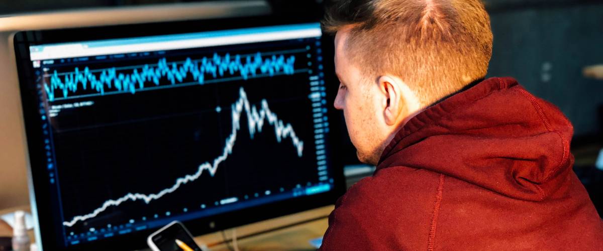 Man investing and checking stocks on computer