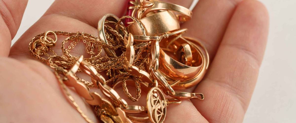 Pile of gold jewellery in hand, closeup shot
