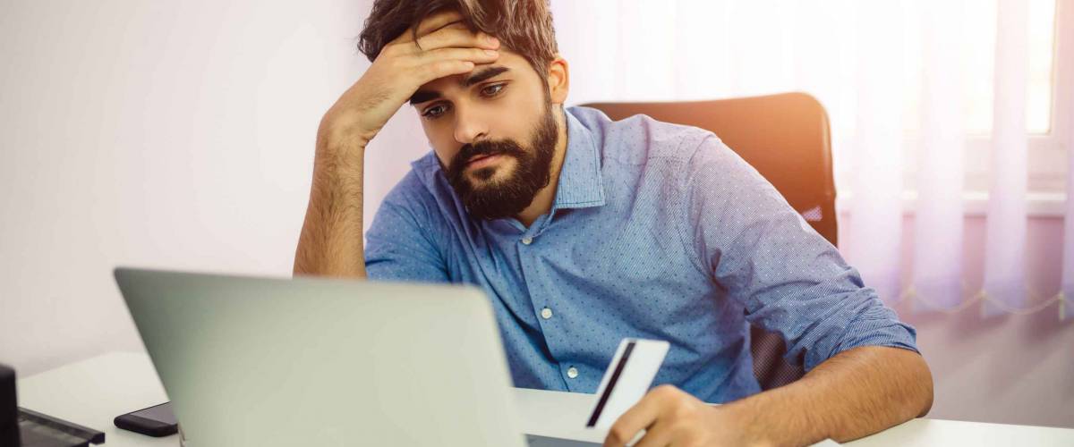 Handsome man feeling disappointed because he misses a chance to buy cheap stuff on auction. Online shopping concept.