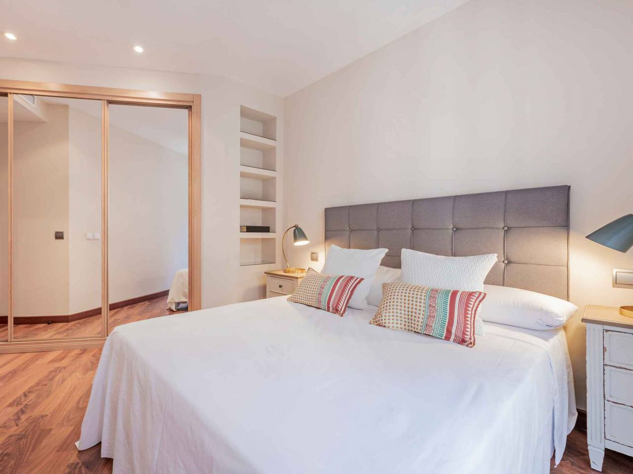 Double bedroom with three-section built-in wardrobe with mirrored doors in a vacation rental home
