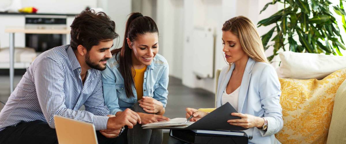 Female Real Estate agent offer home ownership and life insurance to young couple.