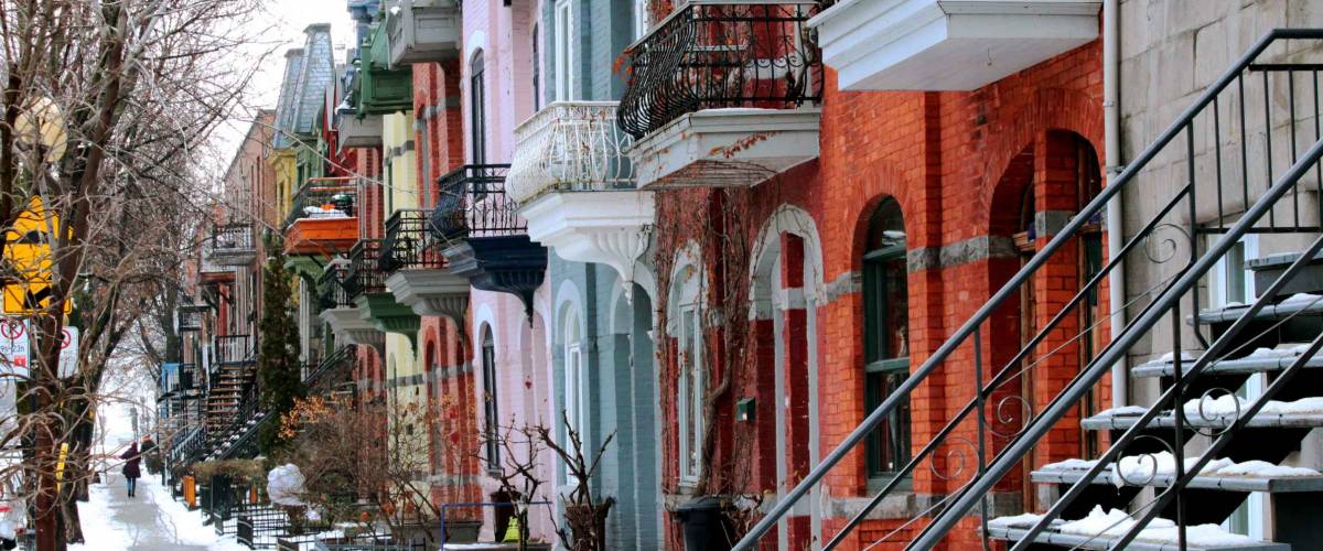 Beautiful houses of old historical Montreal neighborhood Plateau Mont Royal in winter season, bright painted doors.