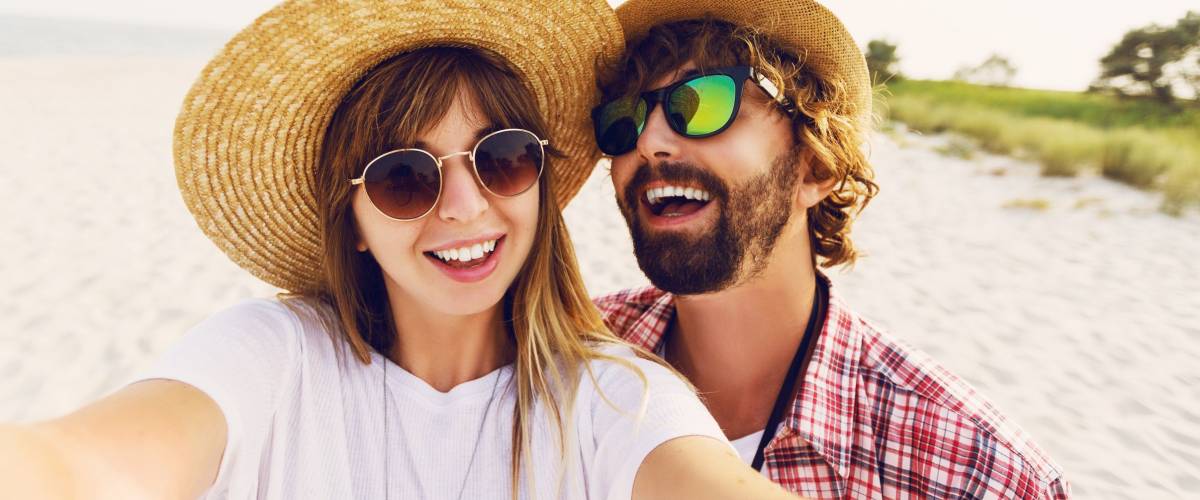 Cute couple posing on the beach taking a selfie.