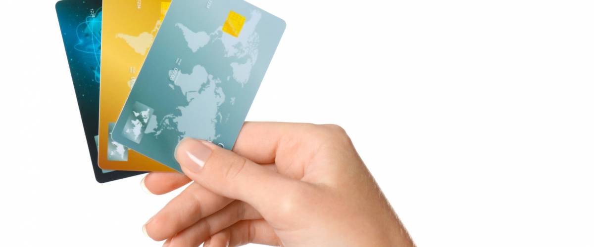 Woman's hand holding credit cards on white background