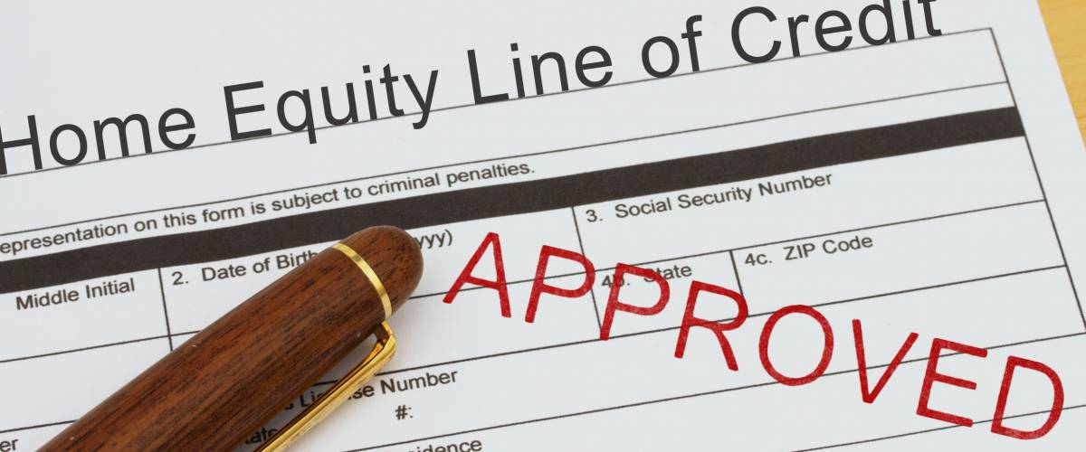 Applying for a Home Equity Line of Credit Approved, Home Equity Line of Credit application form with a pen on a desk with an approved stamp