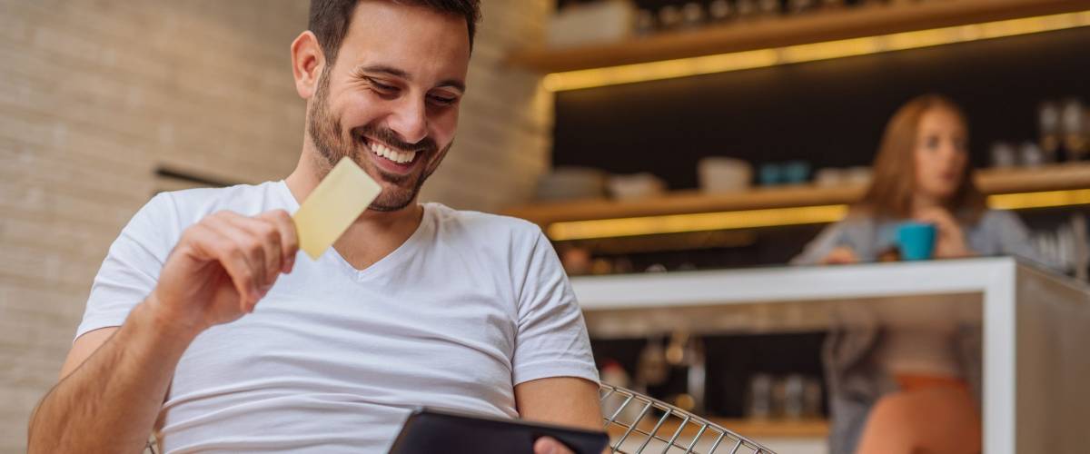 Handsome man shopping from home with a credit card.