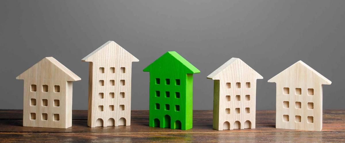 Green figure of a residential building stands out among the rest of the houses