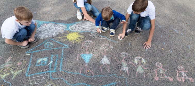 Children draw their large blended family on the street with chalk