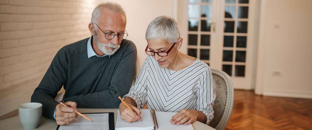 A senior couple taking a closer look at their budget in the comfort of their home.