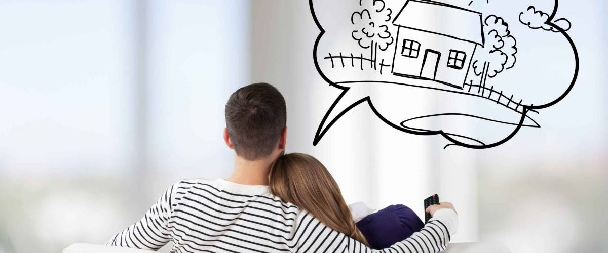 Young Couple Sitting On Sofa thinking about a home