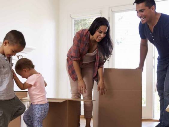 Family Unpacking Boxes In New Home On Moving Day