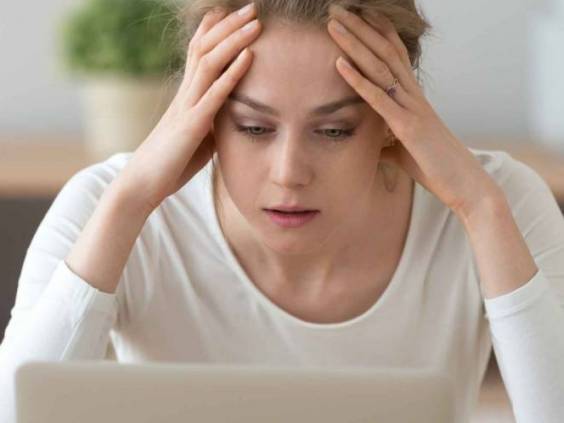 Stressed frustrated young woman student looking at laptop