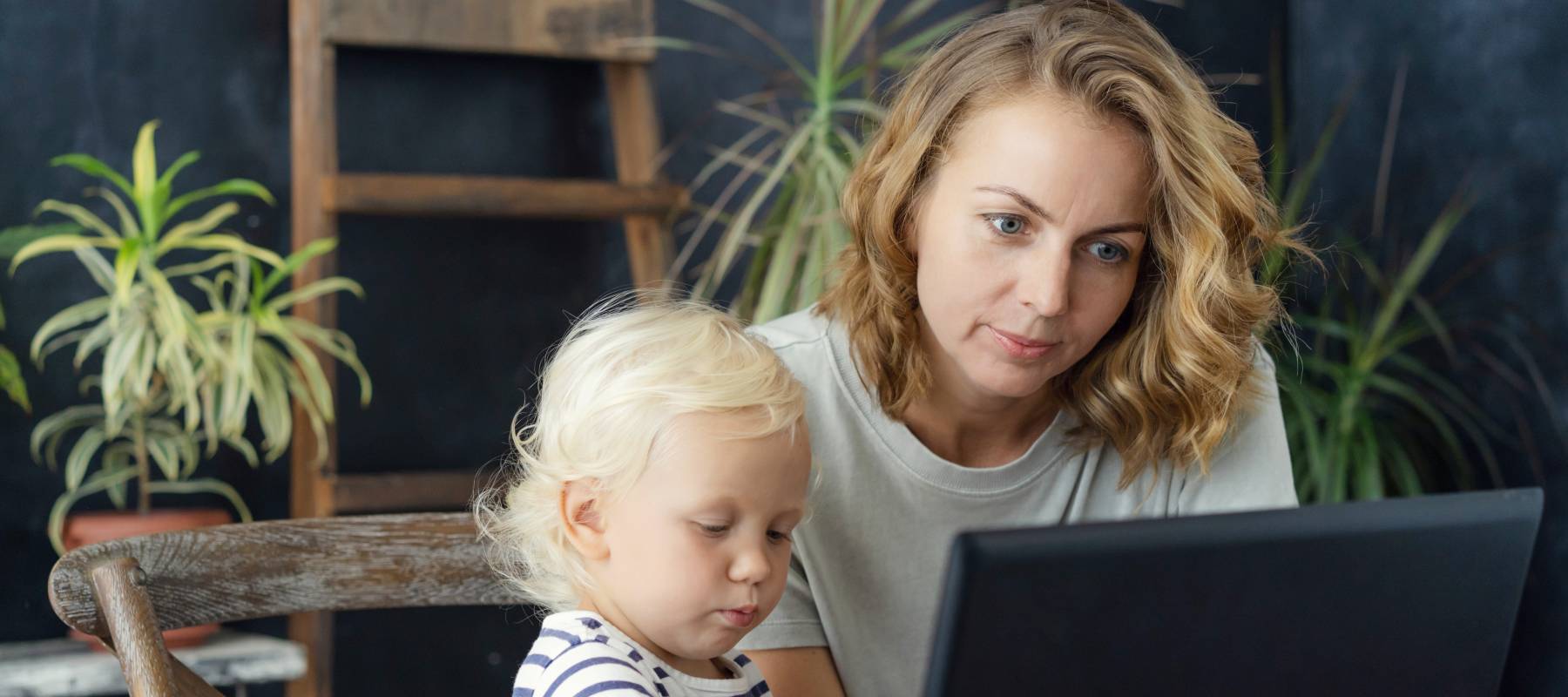 Woman working from home and taking care of her child.